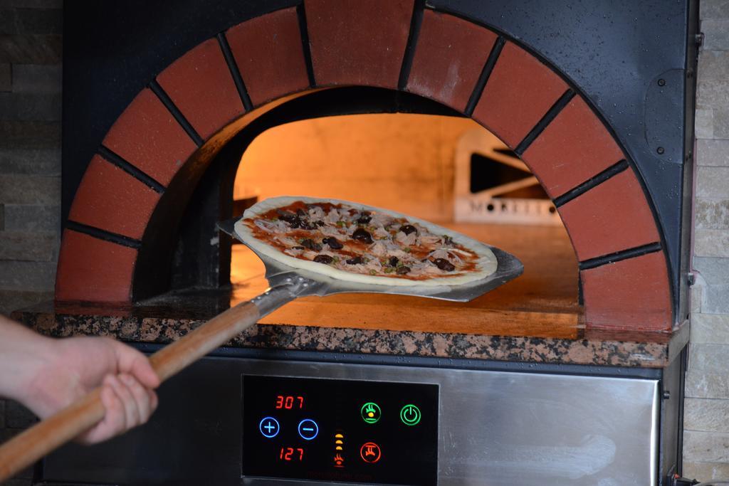 Symphony Style Hotel Kuwait Salmiya ภายนอก รูปภาพ Pizza being removed from a wood-fired oven